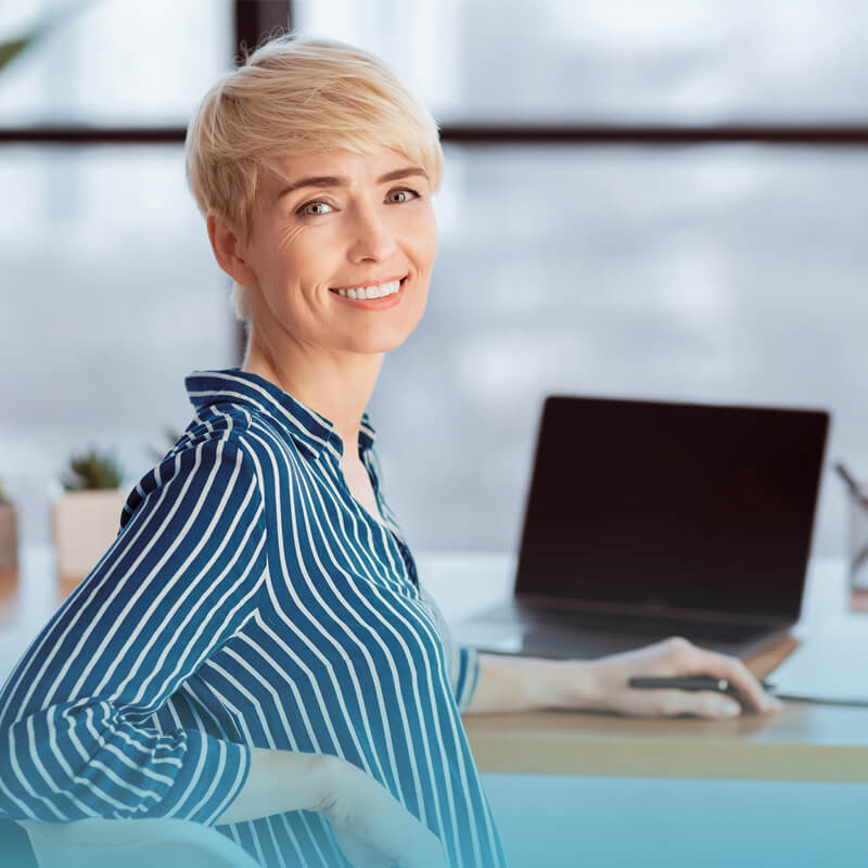 smiling-woman-sitting-at-computer-coach-approach-training-institute